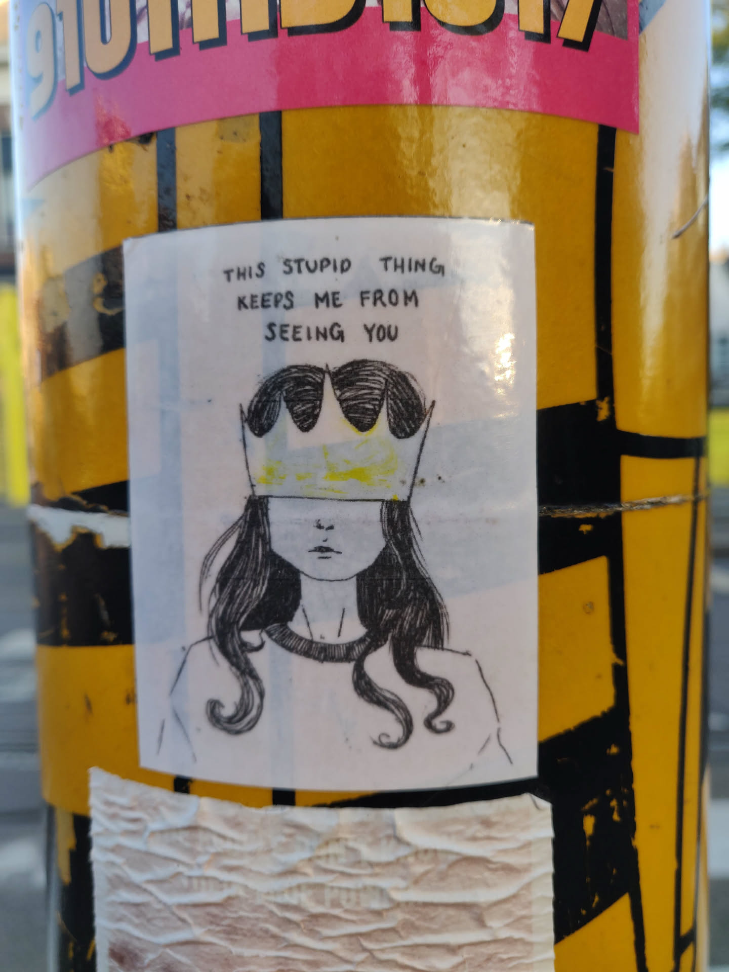 A hand-drawn illustration of a girl wearing a crown that covers her eyes. The text above the illustration reads: "This stupid thing keeps me from seeing you".