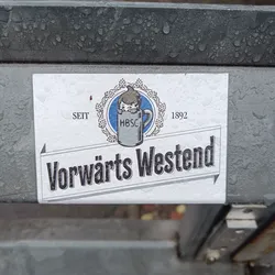 A sticker featuring a vintage-style logo for "Vorwärts Westend", established in 1892. The logo includes an illustration of a child peeking into a beer mug with the abbreviation "HBSC".