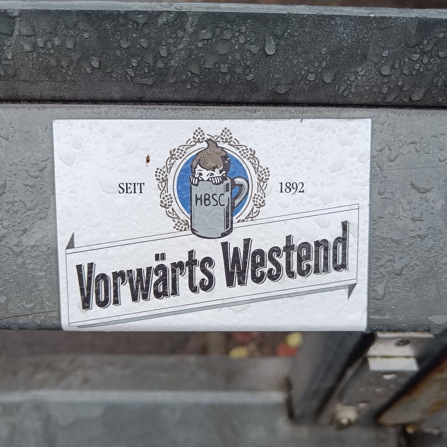 A sticker featuring a vintage-style logo for "Vorwärts Westend", established in 1892. The logo includes an illustration of a child peeking into a beer mug with the abbreviation "HBSC".