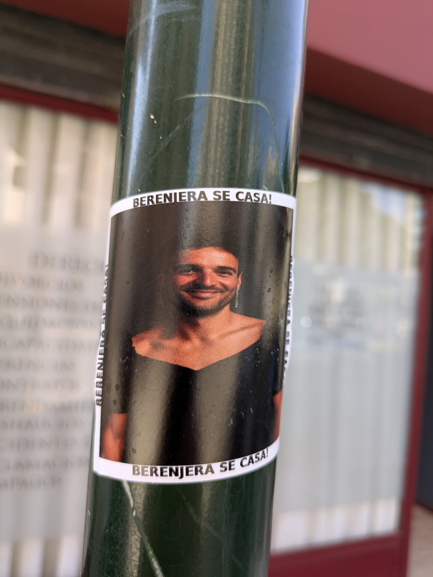 A sticker on a green pole features a smiling person in what appears to be a wedding dress with the text "BERENJERA SE CASA!" at the top and bottom.