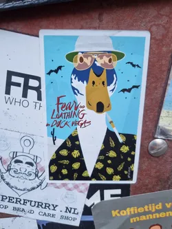 A sticker featuring a cartoon duck wearing sunglasses and a hat, reminiscent of Raoul Duke from Fear and Loathing in Las Vegas. The duck is depicted against a blue background with bats flying around.  It's wearing a black shirt with yellow tropical leaves.