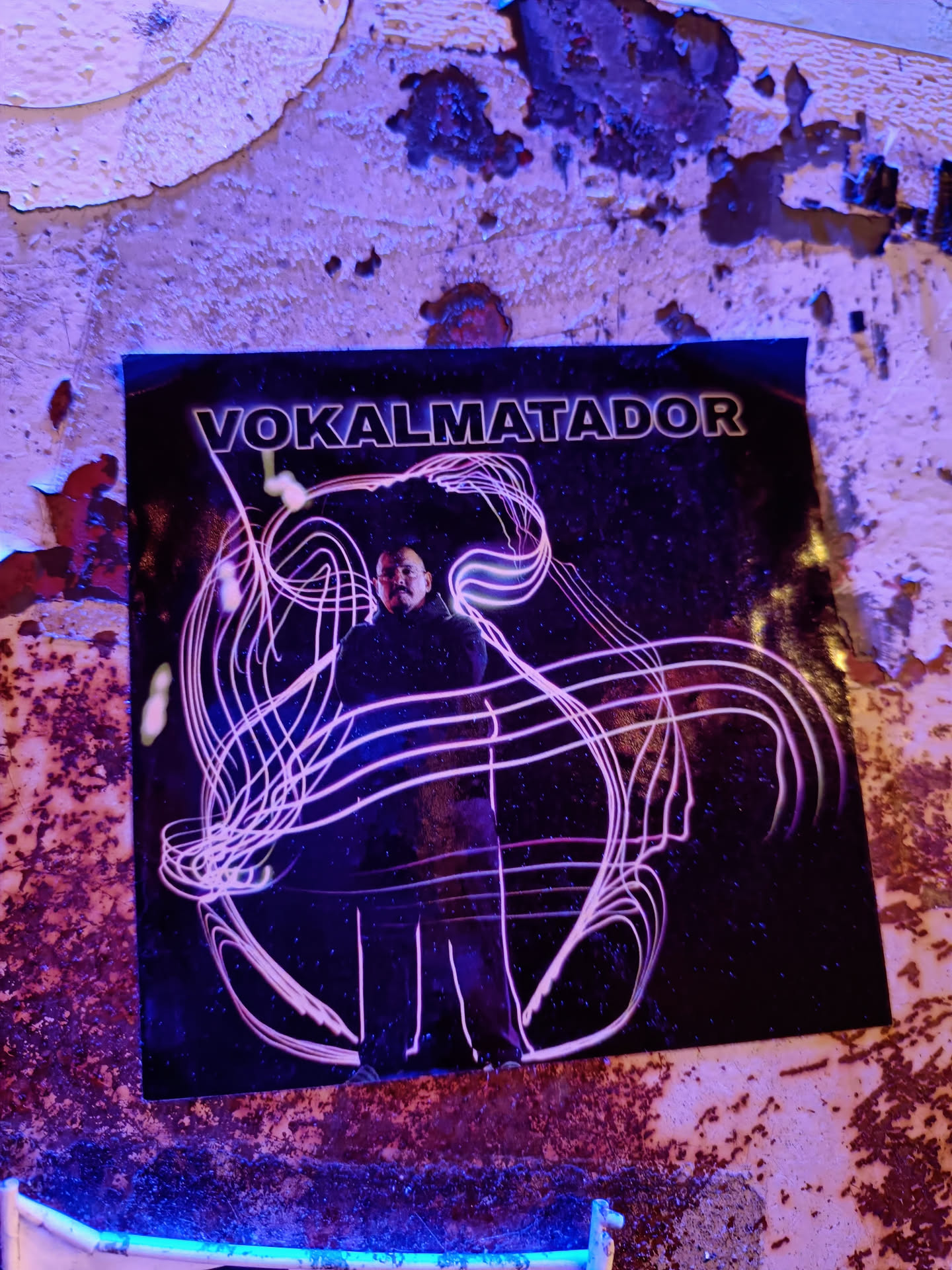 A sticker featuring abstract art with a person in the center. The background is dark and the main figure is outlined with bright pink lines. The text 'VOKALMATADOR' is written at the top of the sticker.
