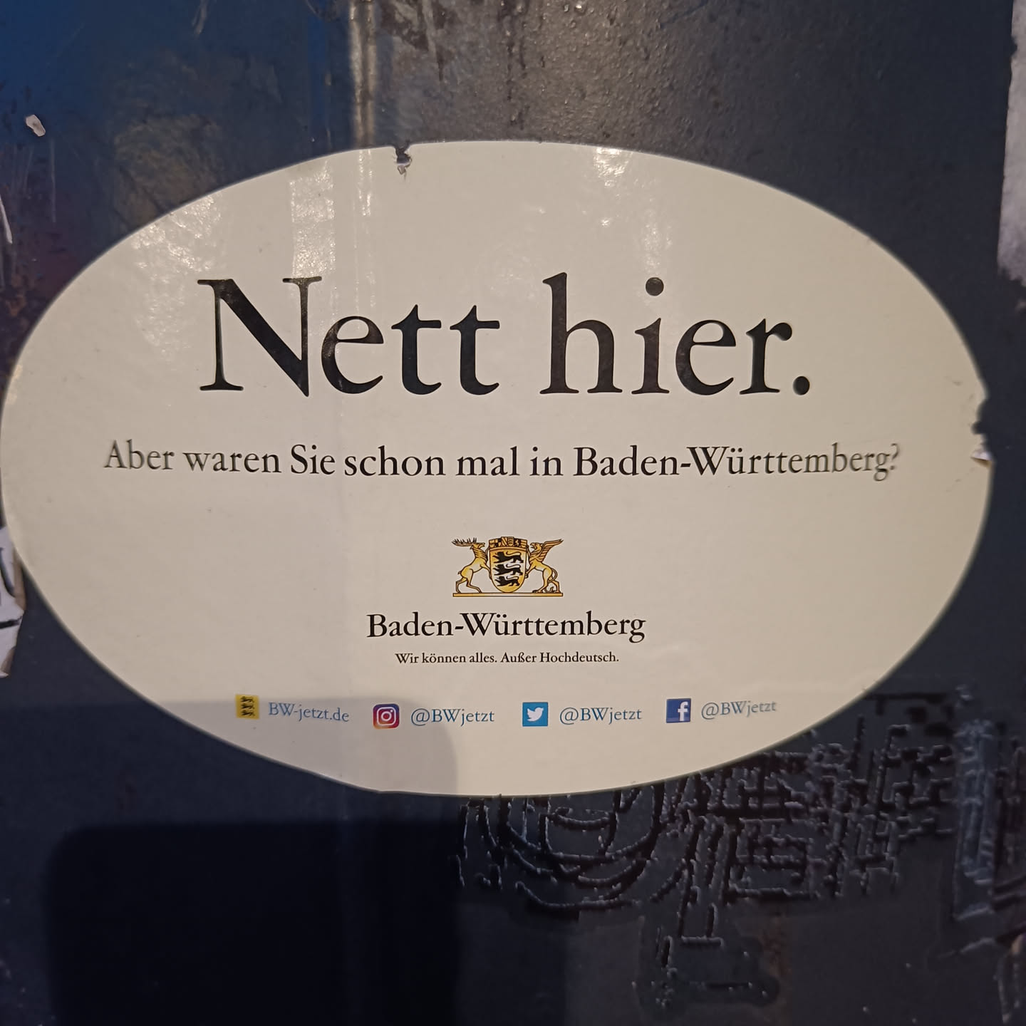 Oval sticker promoting tourism in Baden-Württemberg, Germany.  It features the state's coat of arms and social media handles.