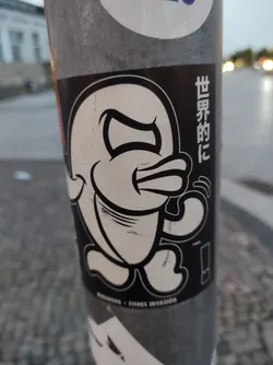 Black and white sticker of an angry cartoon fish. The text on the sticker says "세계적인" which translates to "World" in Korean and "MADAGONE - FISHES INVASION" at the bottom. 