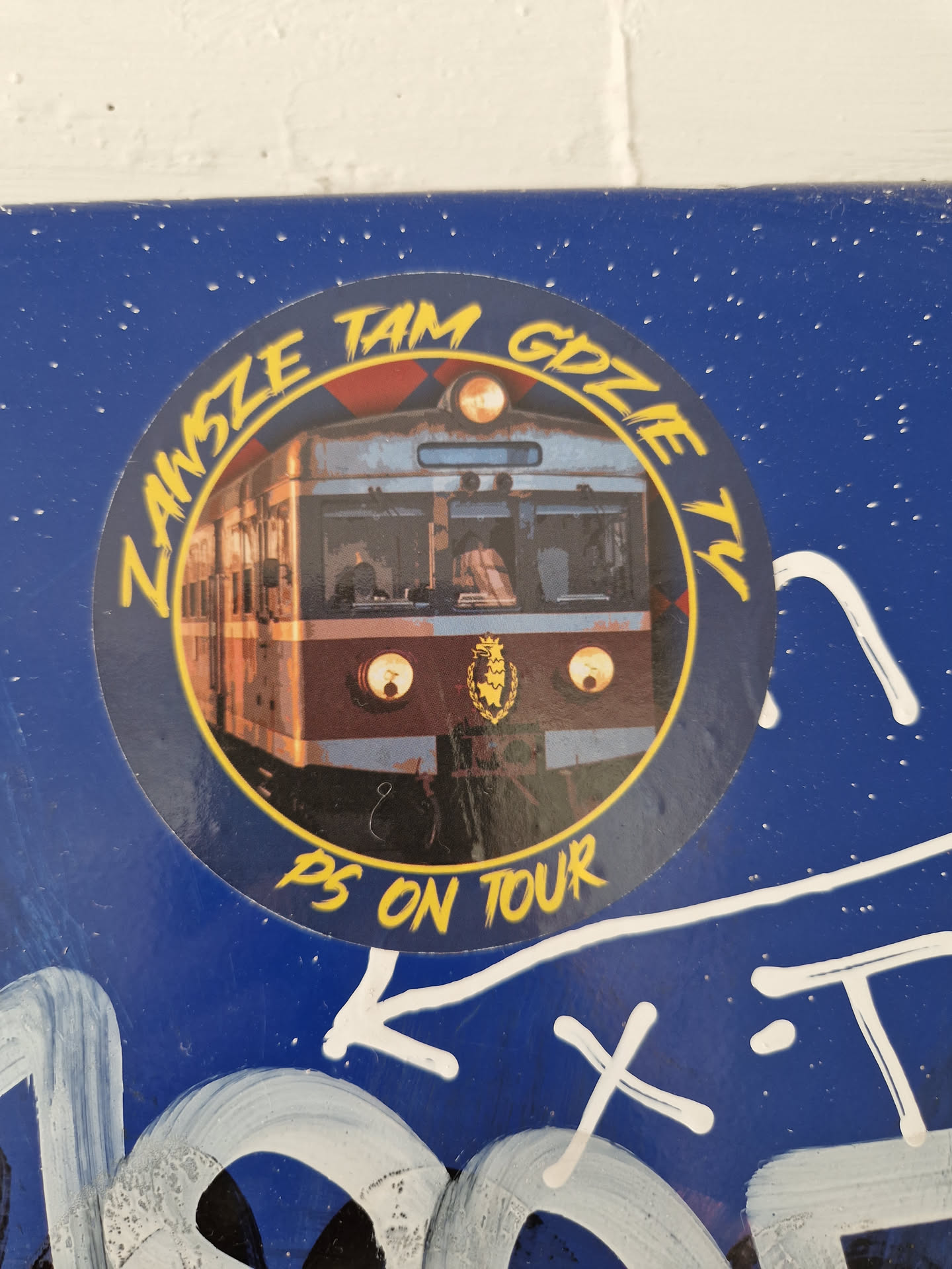 Round sticker featuring an illustration of a train and the text "Zawsze tam gdzie ty" which translates from Polish to "Always where you are" and "PS on tour" at the bottom. The sticker is on a blue background.