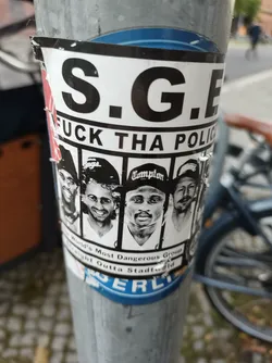 A sticker featuring the acronym S.G.E., the phrase "Fuck Tha Police," and images of several men.  Text below the images indicates they are the "World's Most Dangerous Group Straight Outta Stadtfeld."