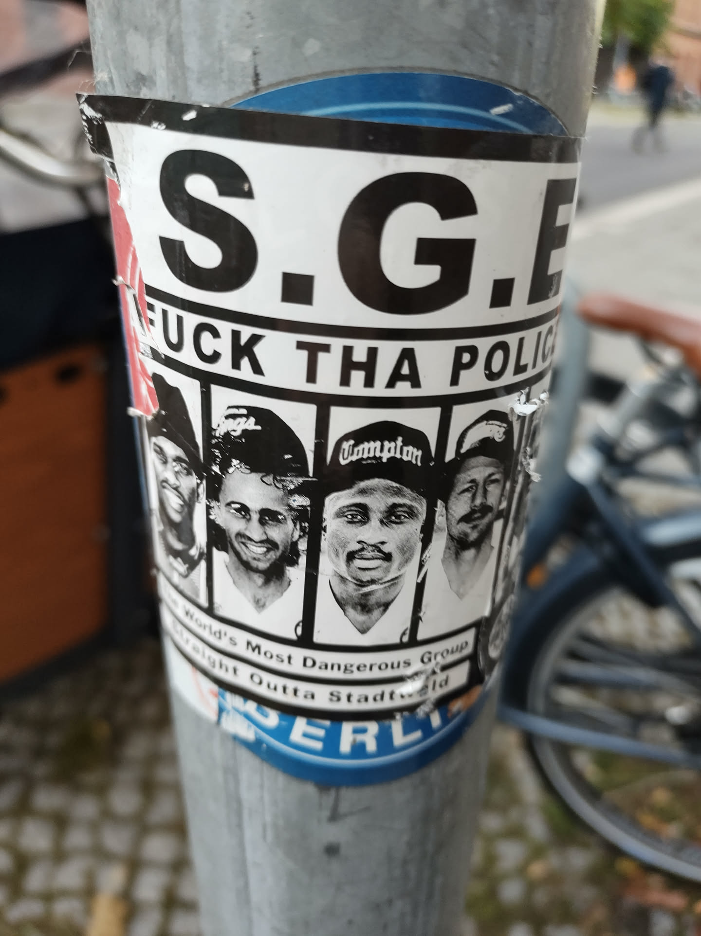 A sticker featuring the acronym S.G.E., the phrase "Fuck Tha Police," and images of several men.  Text below the images indicates they are the "World's Most Dangerous Group Straight Outta Stadtfeld."