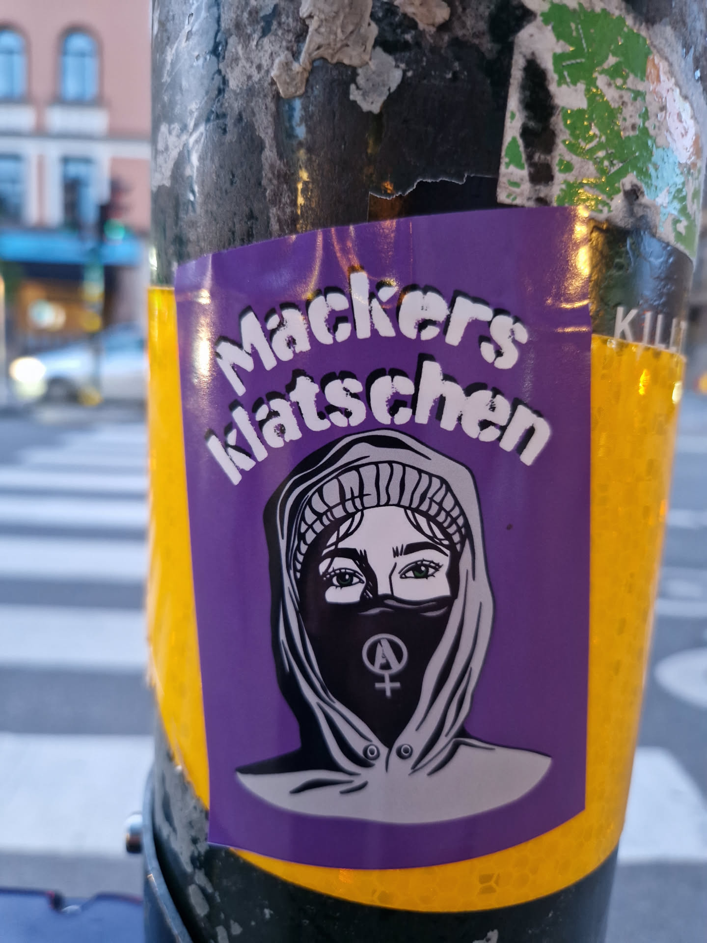 Purple sticker featuring an illustration of a person wearing a hooded jacket and a balaclava with a feminist symbol. The text "Mackers Klatschen" is written at the top.