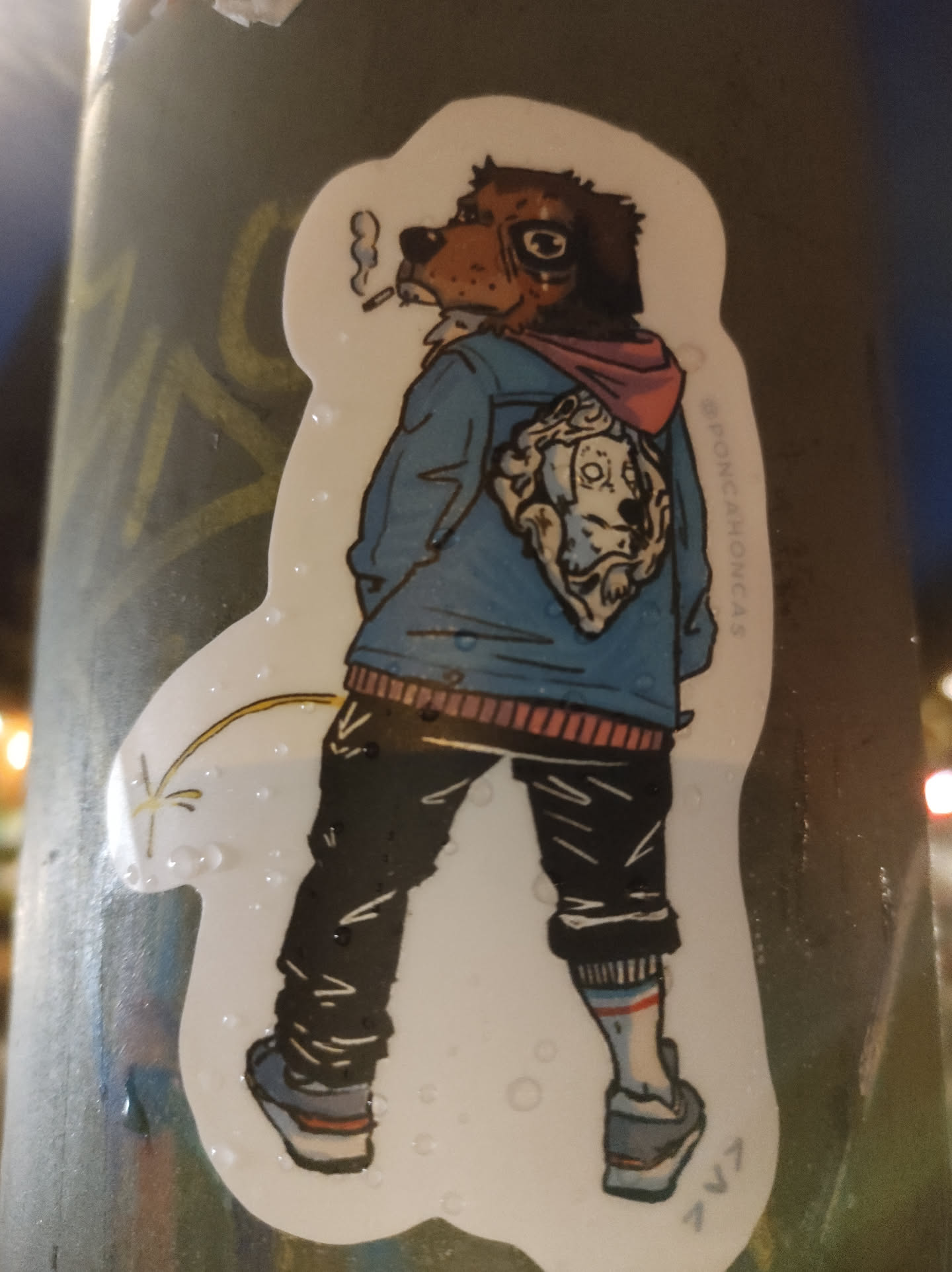Sticker of a dog in a jacket smoking a cigarette and urinating. The dog has a small dog on its back.