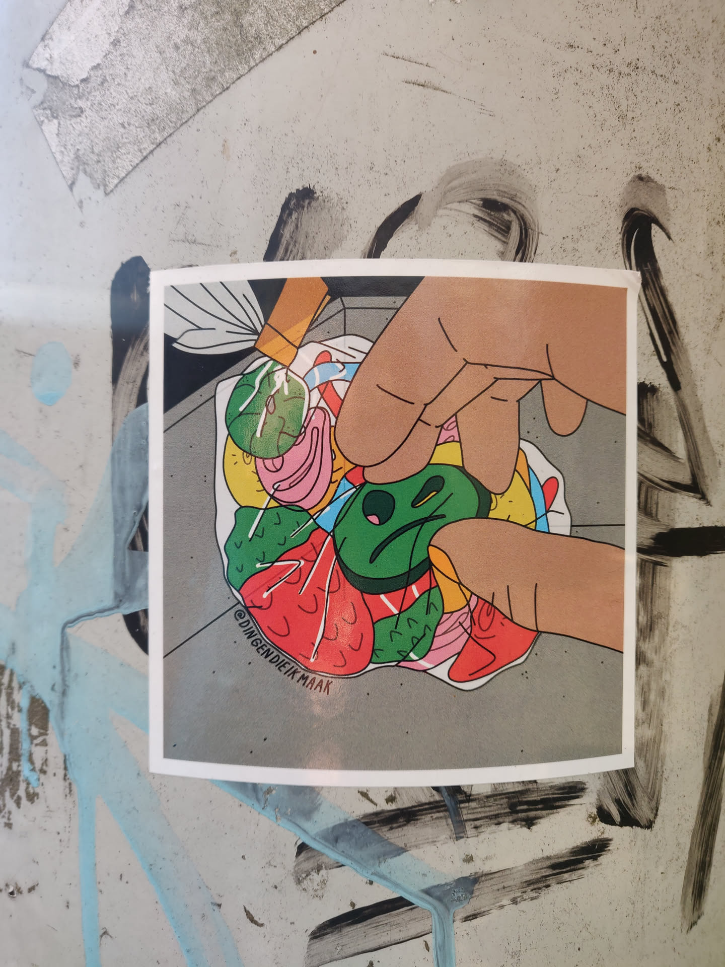 This sticker features a cartoon illustration of a hand selecting a green circular candy from a pile of various colorful sweets inside a plastic bag. The style is bold and graphic with flat colors and outlines. The artist's Instagram handle (@dingendieikmaak) is visible in the bottom left corner of the artwork.