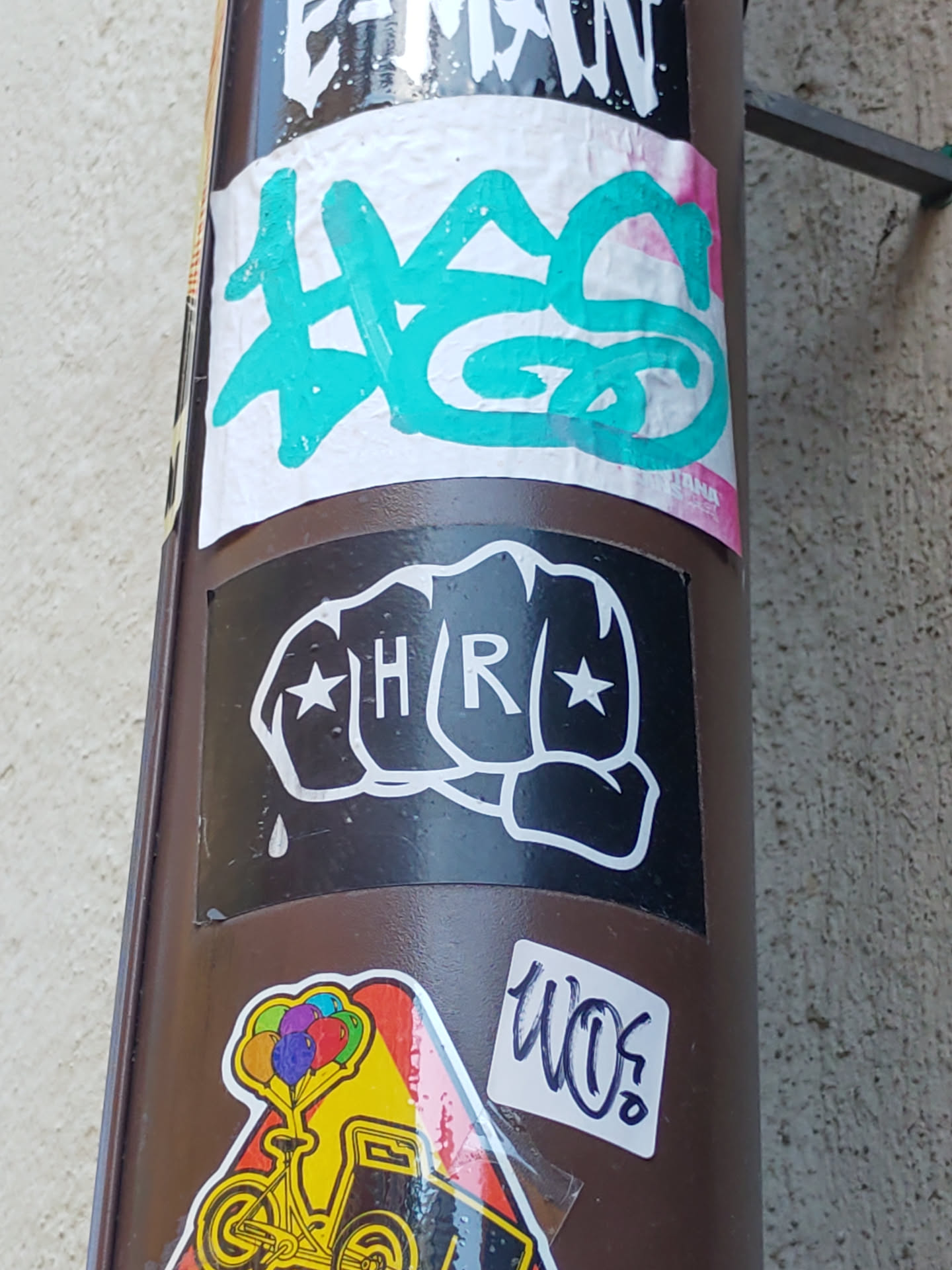 Black and white sticker of a fist with HR in the center and stars on each side. There is a single droplet below the fist.