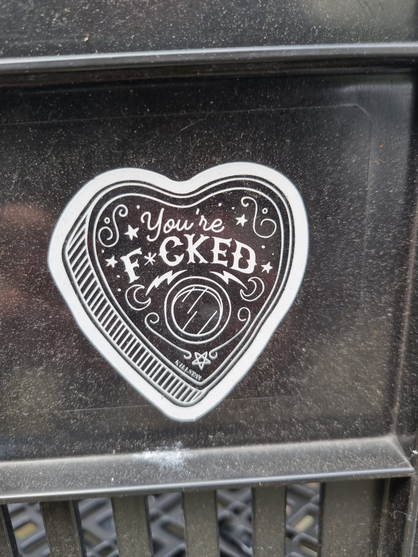 A heart-shaped planchette sticker with the text "You're F*cked" in a vintage style.