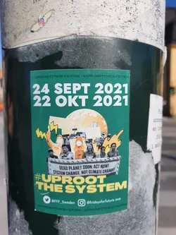 A sticker advocating for system change, not just climate change.  It features a graphic of a protest and the dates of potential events. Social media handles for Fridays For Future Sweden are included.