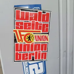 A sticker featuring the text "Waldseite" above the logo of 1. FC Union Berlin, with the club's name written in large, stylized letters below. The color scheme consists primarily of red and black, with yellow accents in the logo.