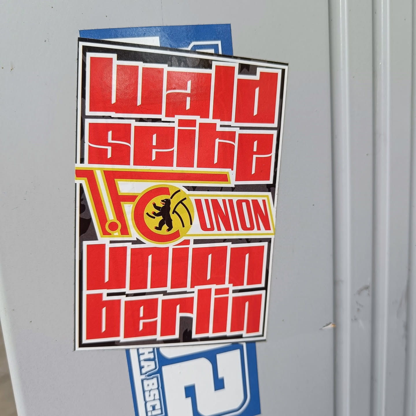 A sticker featuring the text "Waldseite" above the logo of 1. FC Union Berlin, with the club's name written in large, stylized letters below. The color scheme consists primarily of red and black, with yellow accents in the logo.