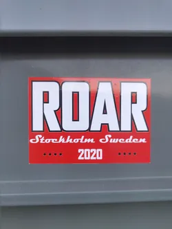 A red sticker with the word ROAR in bold white capital letters. Below it says Stockholm Sweden and 2020.