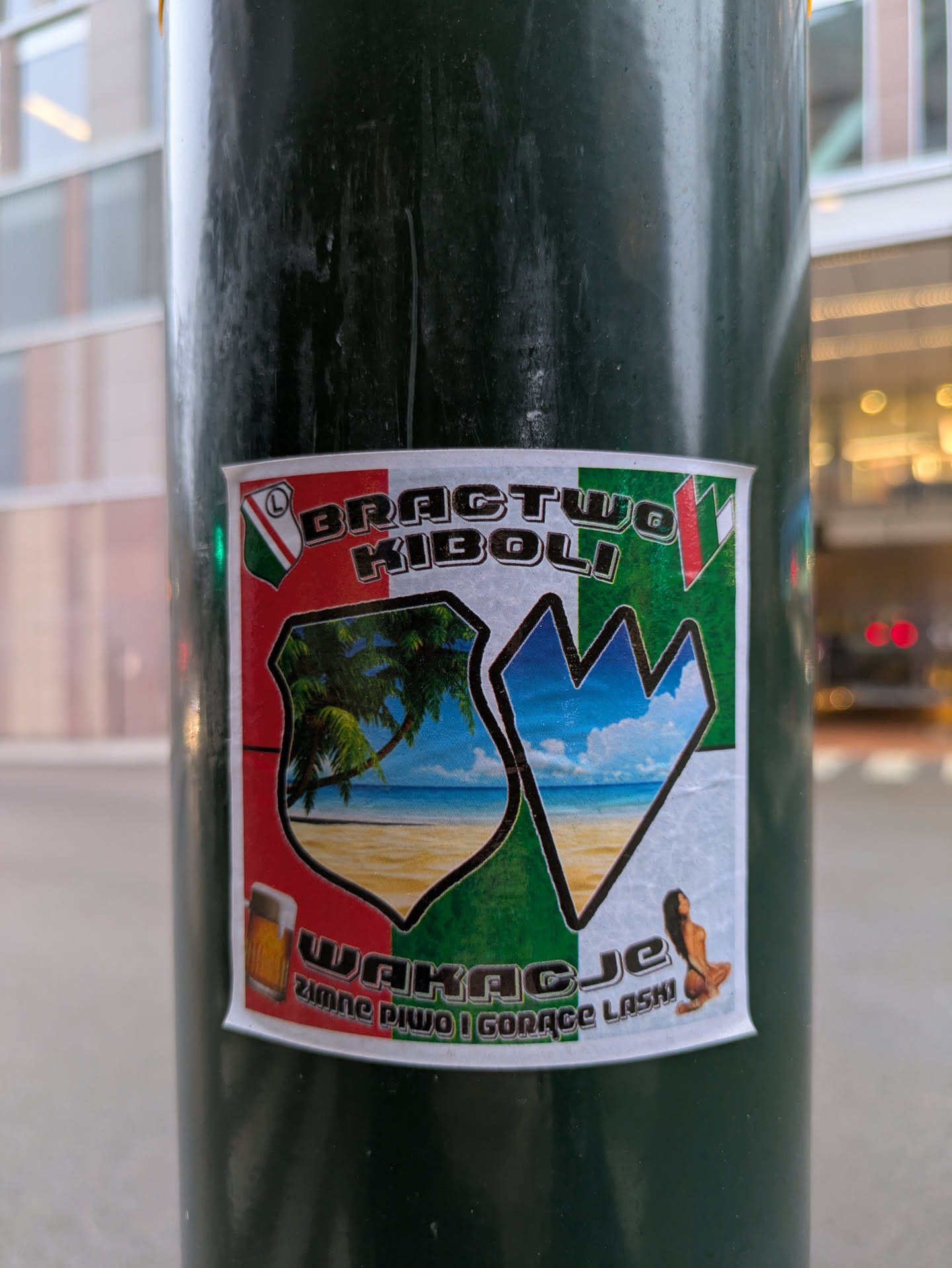 The sticker features a shield-like design with a beach scene and a mountain range. It includes the text "BRACTWO KIBOLI" and "WAKACJE zimne PIWO I GORĄCE LASKI". The sticker appears to be related to football fans and vacation theme with cold beer and hot babes.