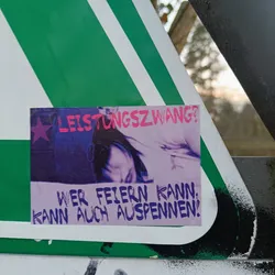 A sticker featuring a stylized image of a person's face and the text: "LEISTUNGSZWANG? Wer feiern kann, kann auch auspennen!" which translates to: "Performance pressure? Those who can party can also chill!"