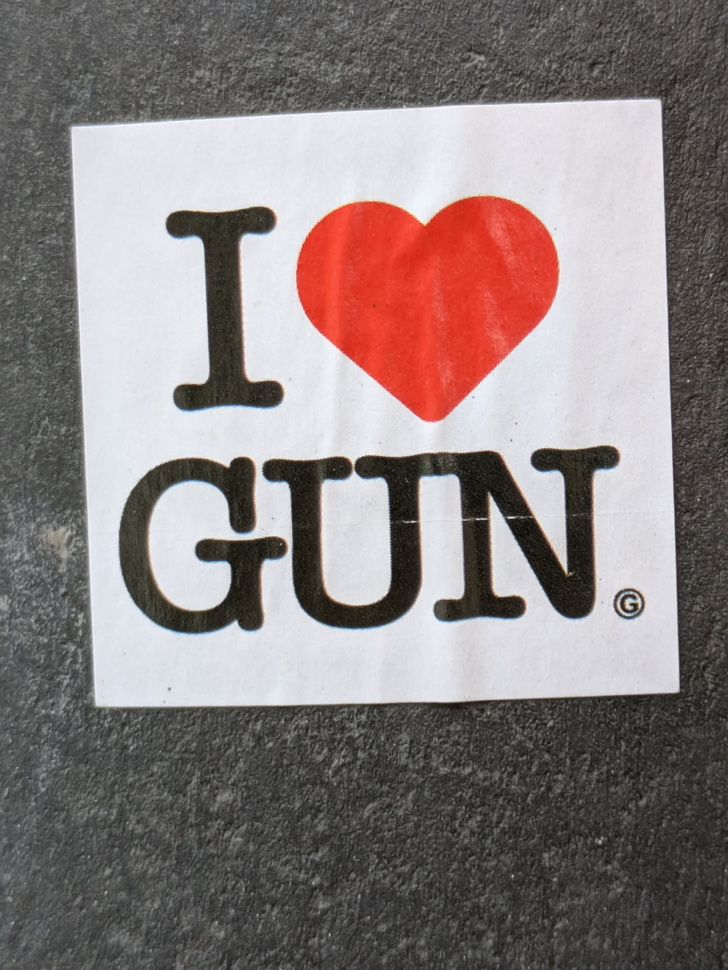A sticker with a red heart and the text "I ♥ GUN".