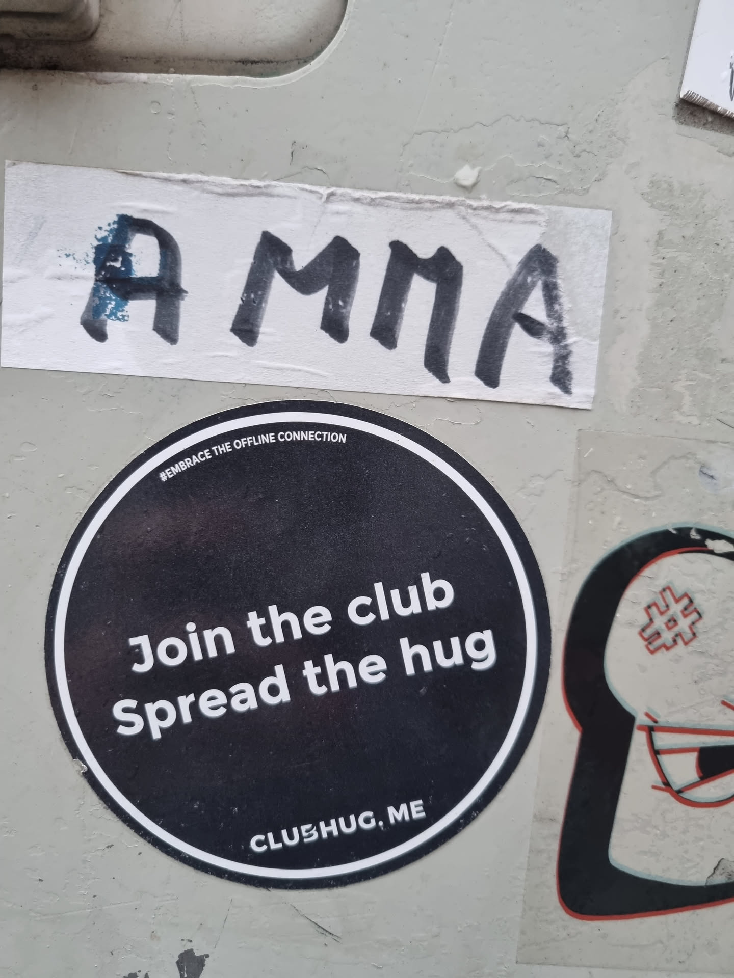 Round black and white sticker with the text "Join the club Spread the hug" and the website address ClubHug.me.  The text "Embrace the offline connection" is also visible in smaller font above the main text.