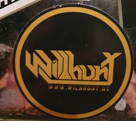 Round black and gold sticker with the word WildHunt in a stylized font.  The text "www.wildhunt.at" is printed below the logo.