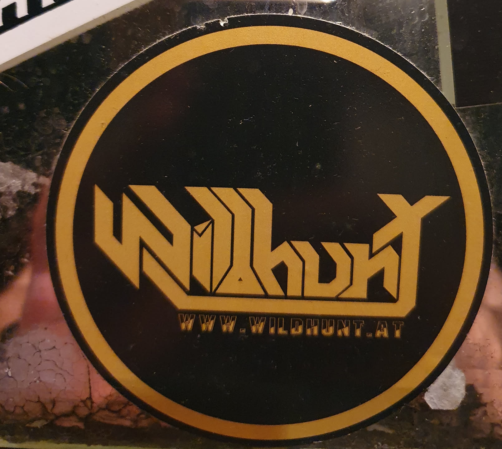Round black and gold sticker with the word WildHunt in a stylized font.  The text "www.wildhunt.at" is printed below the logo.