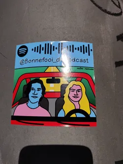 A sticker featuring an illustration of two people in a car. The illustration is in a minimalist style with bold colors. The sticker includes a Spotify code linking to the Bonnefooi podcast and the podcast's Instagram handle. 