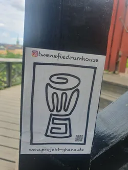 A black and white sticker with a drawing of a drum and a QR code.  It promotes Project Ghana and mentions tweneifieddrumhouse on Instagram.