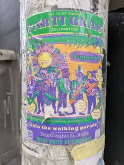 The sticker is a promotional flyer for the Third Annual Arti Gras Celebration on August 19. It features a band in colorful costumes.