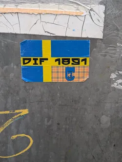Street sticker A rectangular sticker designed around the blue and yellow flag of Sweden. Running horizontally along the yellow cross is the bold black text 'DIF 1891'. The bottom-right quadrant of the flag is replaced by a beige tartan/plaid pattern containing a blue crest emblem with a white outline.