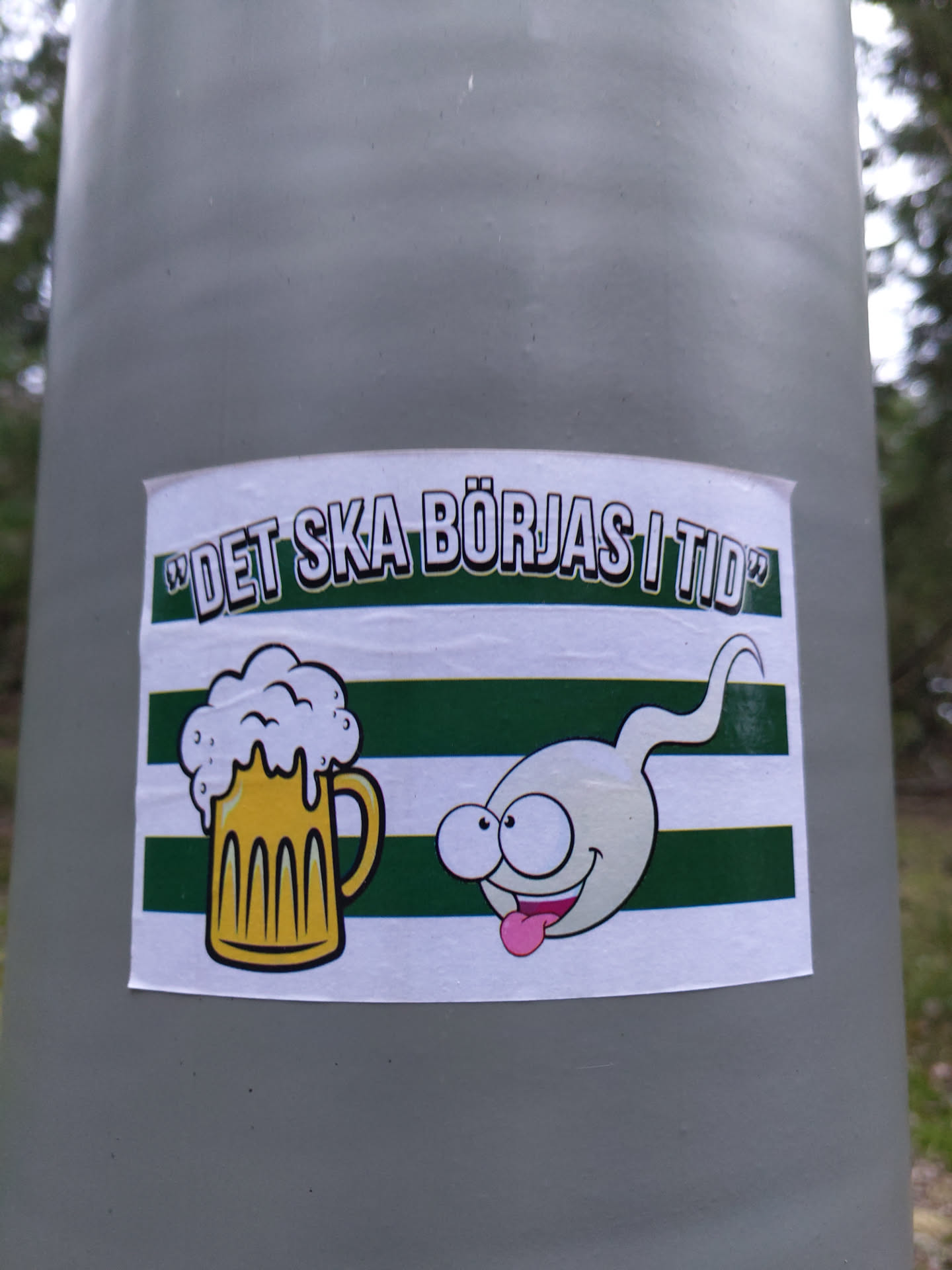 A sticker featuring a cartoon beer mug and a sperm cell with a funny expression. The text on the sticker translates to "It should be started on time" in Swedish.