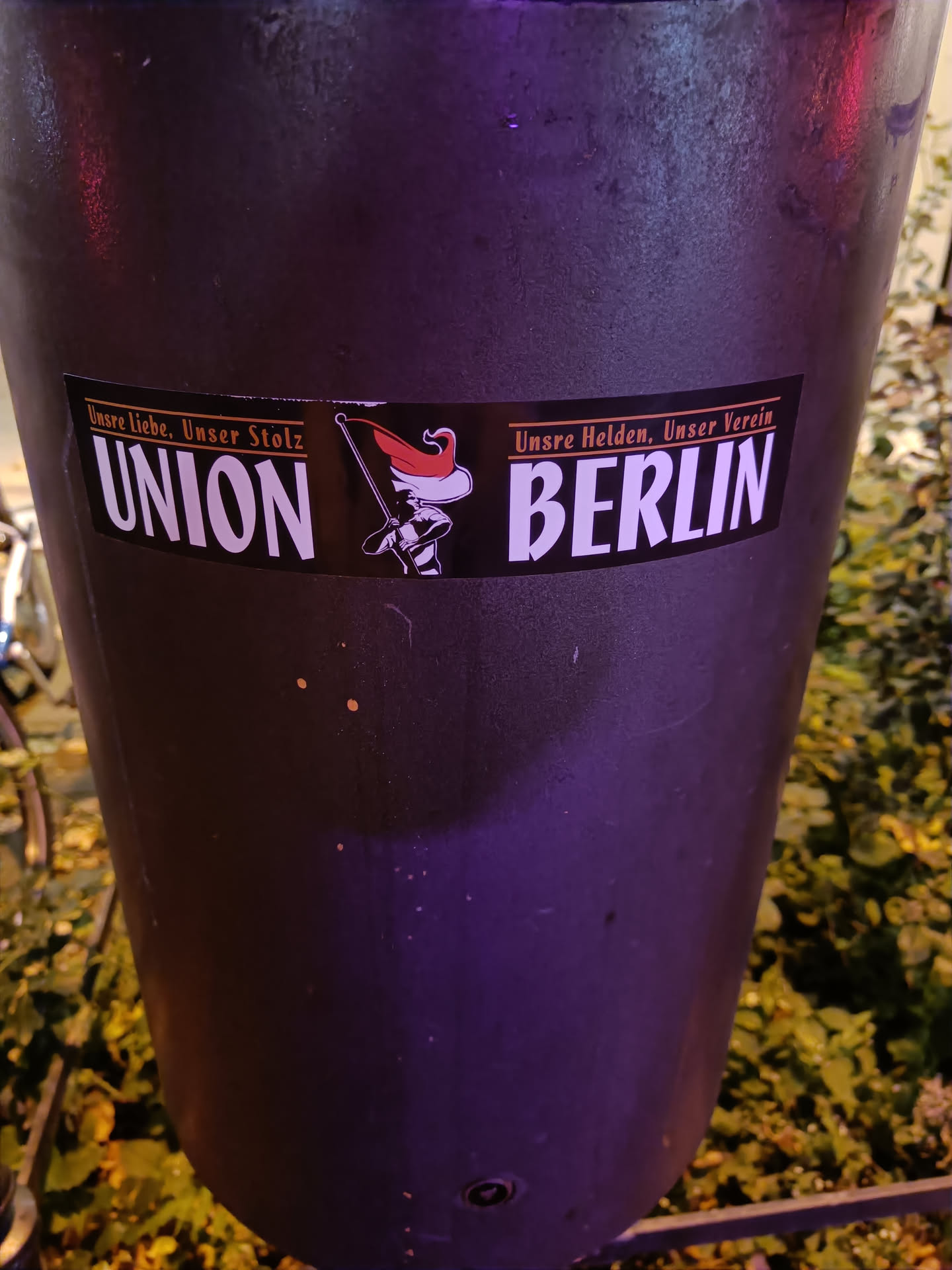 A black sticker with the text "UNION BERLIN" in white.  There is a small graphic of what looks like a soldier or mascot to the left of "UNION" and small text above and below the main text. The small text is partially visible and appears to be in German.