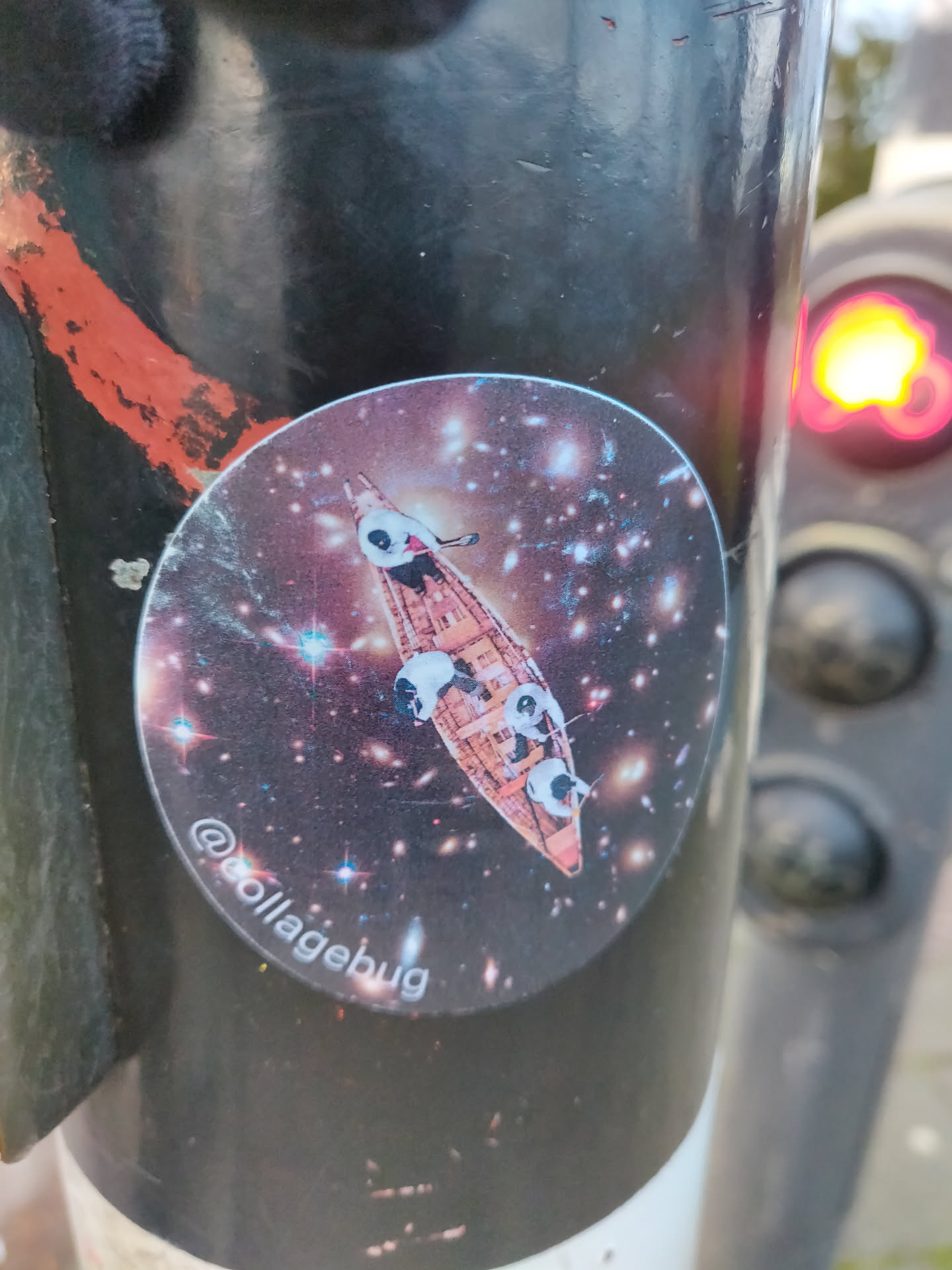 A round sticker featuring an illustration of pandas in a boat traversing a cosmic space filled with galaxies and stars. The sticker has a dark background with sparkling elements, creating a visually captivating scene.