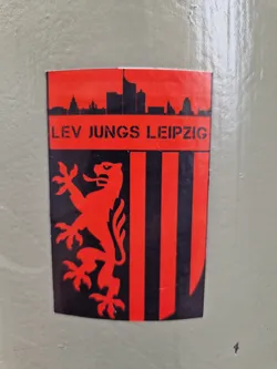 A red and black sticker with the text "LEV JUGS LEIPZIG" and a lion emblem.  The sticker also features a cityscape skyline.