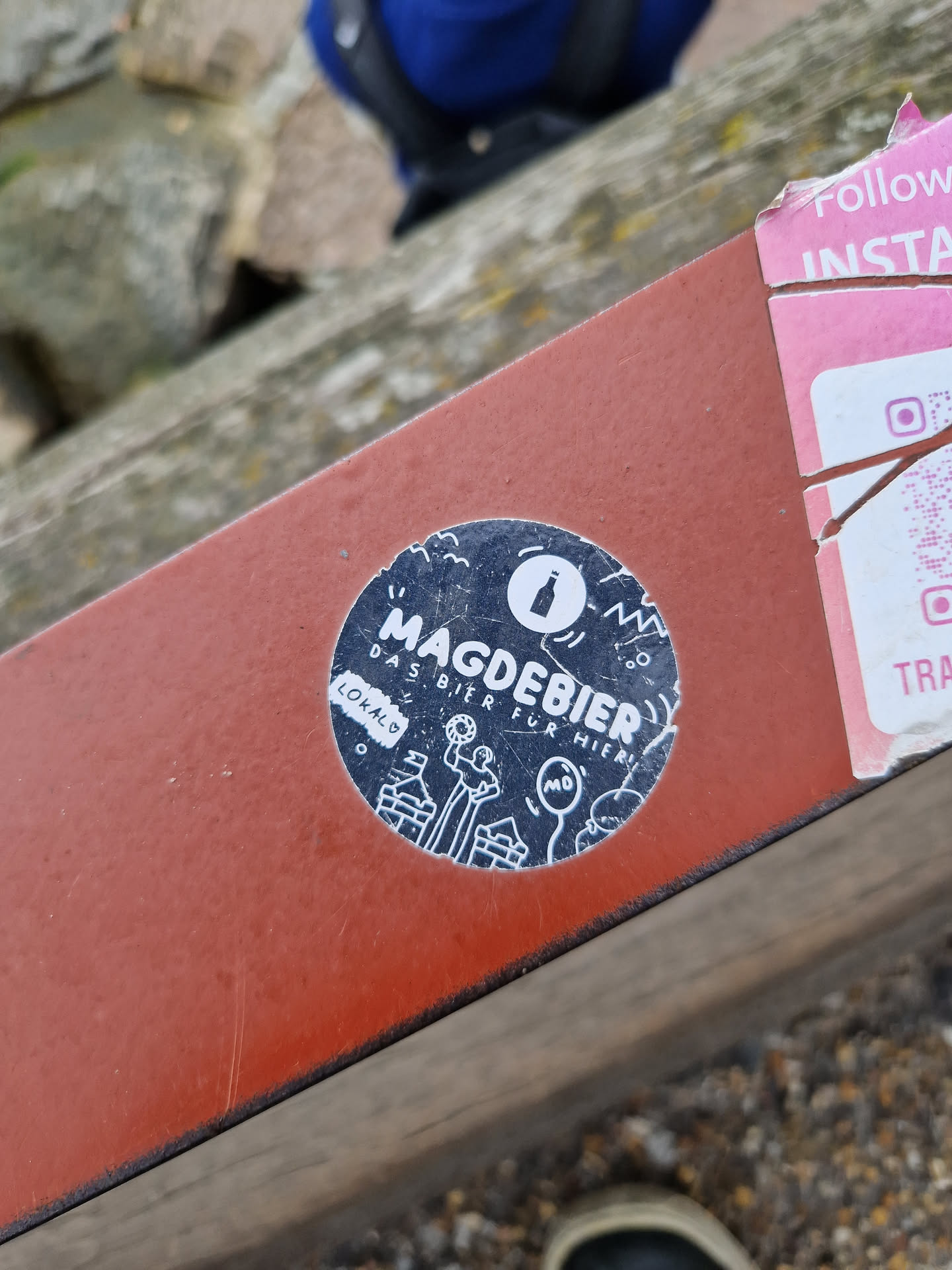 A round black and white sticker with illustrations and text.  The text says "Magdebier" prominently, with smaller text that reads "Das Bier für Magdeburg" (The beer for Magdeburg) and "Lokalo".  The illustrations depict people and buildings, suggesting a local brewery or beer brand from Magdeburg.