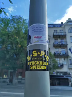 A black and yellow sticker on a pole in Stockholm, Sweden, with the text "S.S.P.C. since 1981 STOCKHOLM SWEDEN".