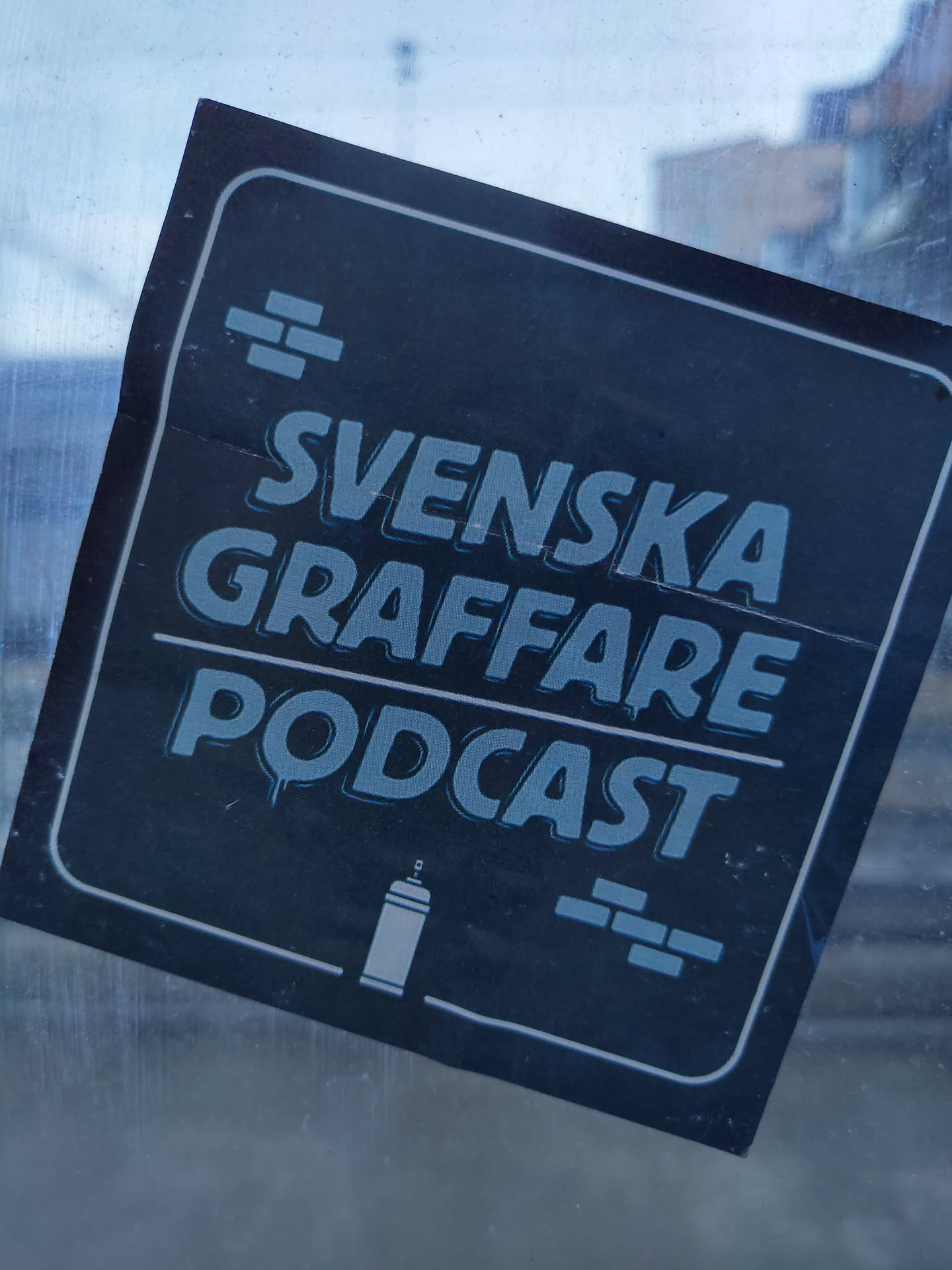 A sticker for the Swedish GrafFare podcast. It features the podcast's name in stylized lettering, along with icons of a spray can and bricks. The color scheme is predominantly dark blue and light blue on a black background.