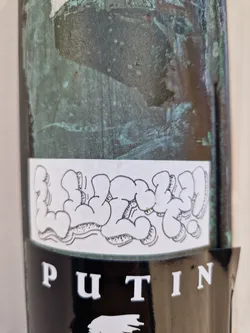 A sticker with a graffiti-style design and the word PUTIN at the bottom. The graffiti design is in black and white and features stylized bubble letters.