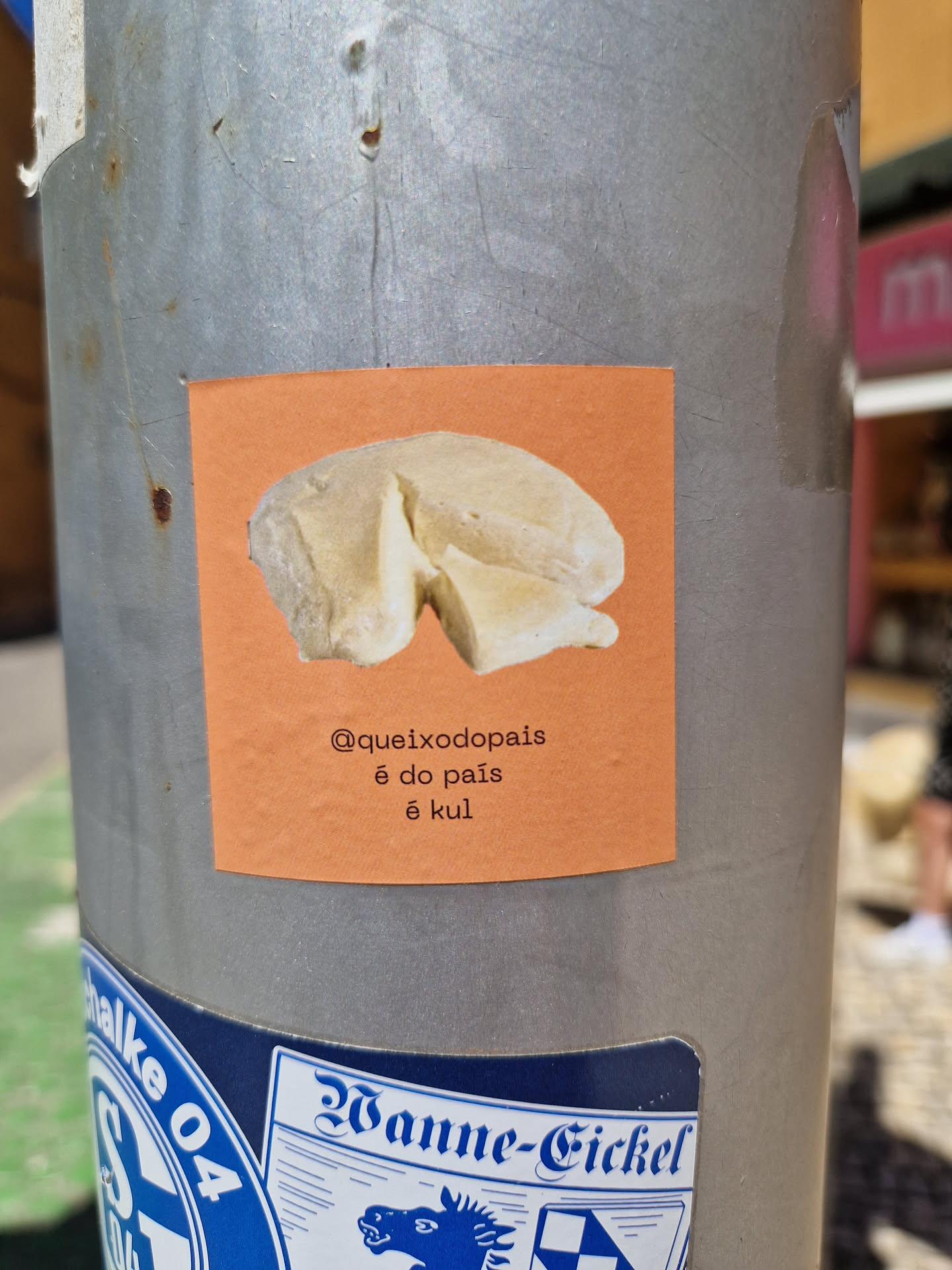 A sticker featuring an illustration of Queijo do País cheese, a traditional Portuguese cheese. The sticker has a simple design with an orange background and white text.