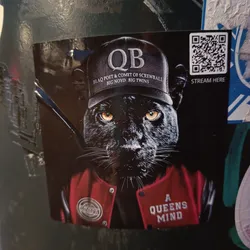 A sticker featuring a black panther wearing a baseball cap with the letters "QB" and the names "Blaq Poet & Comet of Screwball, Big Noyd, Big Twins" on it. It's also wearing a red varsity jacket with the words "A Queens Mind" on the back. There is a QR code in the corner.