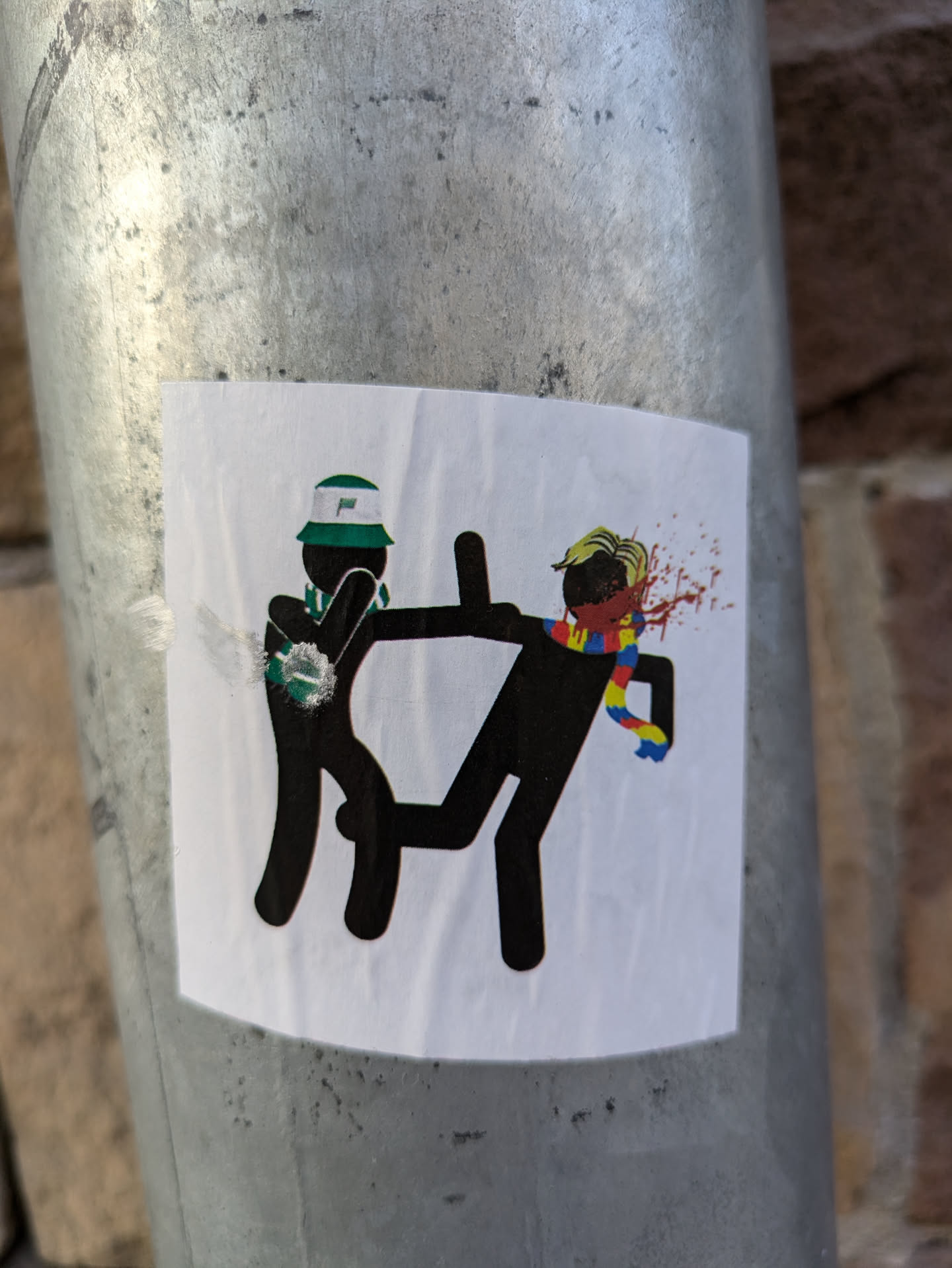 The sticker shows a simple, yet violent, scene between two stick figures. One is clearly the attacker, dressed in a bucket hat, while the other is the victim, bleeding from a head injury. The style is minimalistic, relying on bold black lines and limited color.