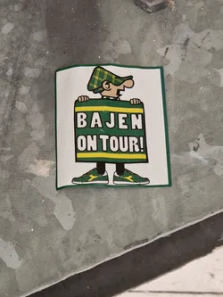 A sticker featuring a cartoon character holding a sign that says "Bajen On Tour!"