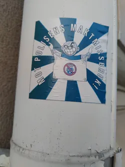 A sticker featuring a cartoon character holding a sign with a prohibition symbol. The text around the image says "Mot polisens maktmissbruk!" which translates to "Against police abuse of power!"