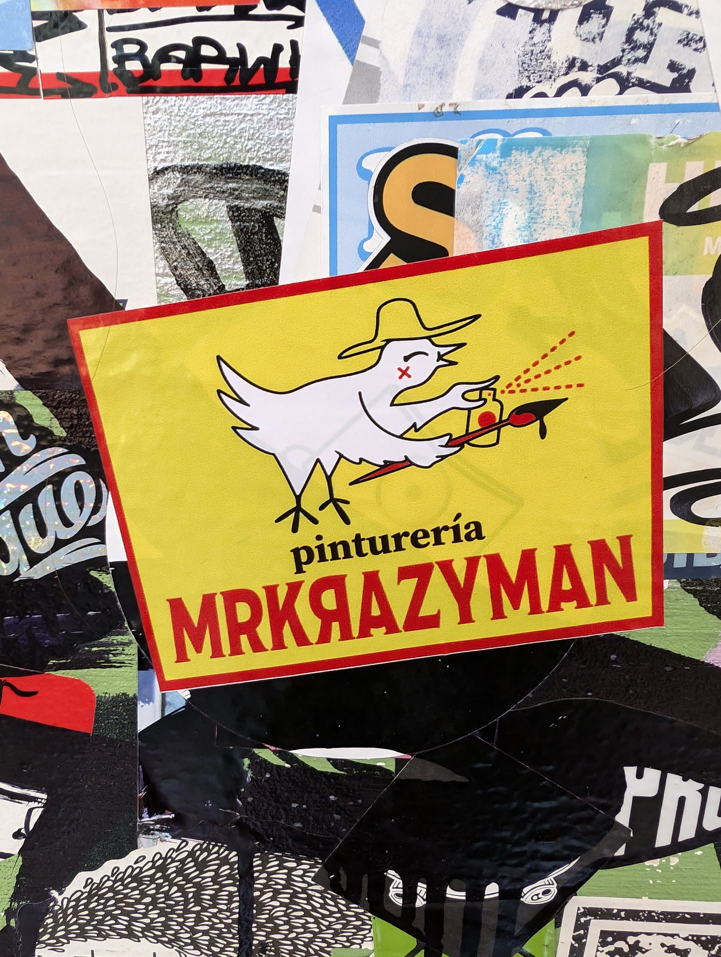 Yellow sticker featuring a cartoon bird wearing a sombrero, holding a spray can and paintbrush.  Text on the sticker says "pintureria MRKRAZYMAN".