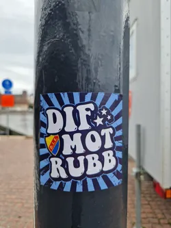 A blue and white sticker with the text "DIF MOT RUBB" in a retro style. It features a small logo in the corner and a star.