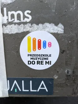 Round sticker with a xylophone illustration and the text "Przedszkole Muzyczne Do Re Mi" (Music Preschool Do Re Mi) in Polish.