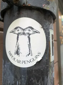 Street sticker A round sticker featuring a drawing of two penguins joined together at the body, with the text 'Bipolar Penguins' written below the drawing.