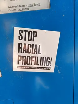 A sticker expressing protest against racial profiling.  It features bold text and a website address.
