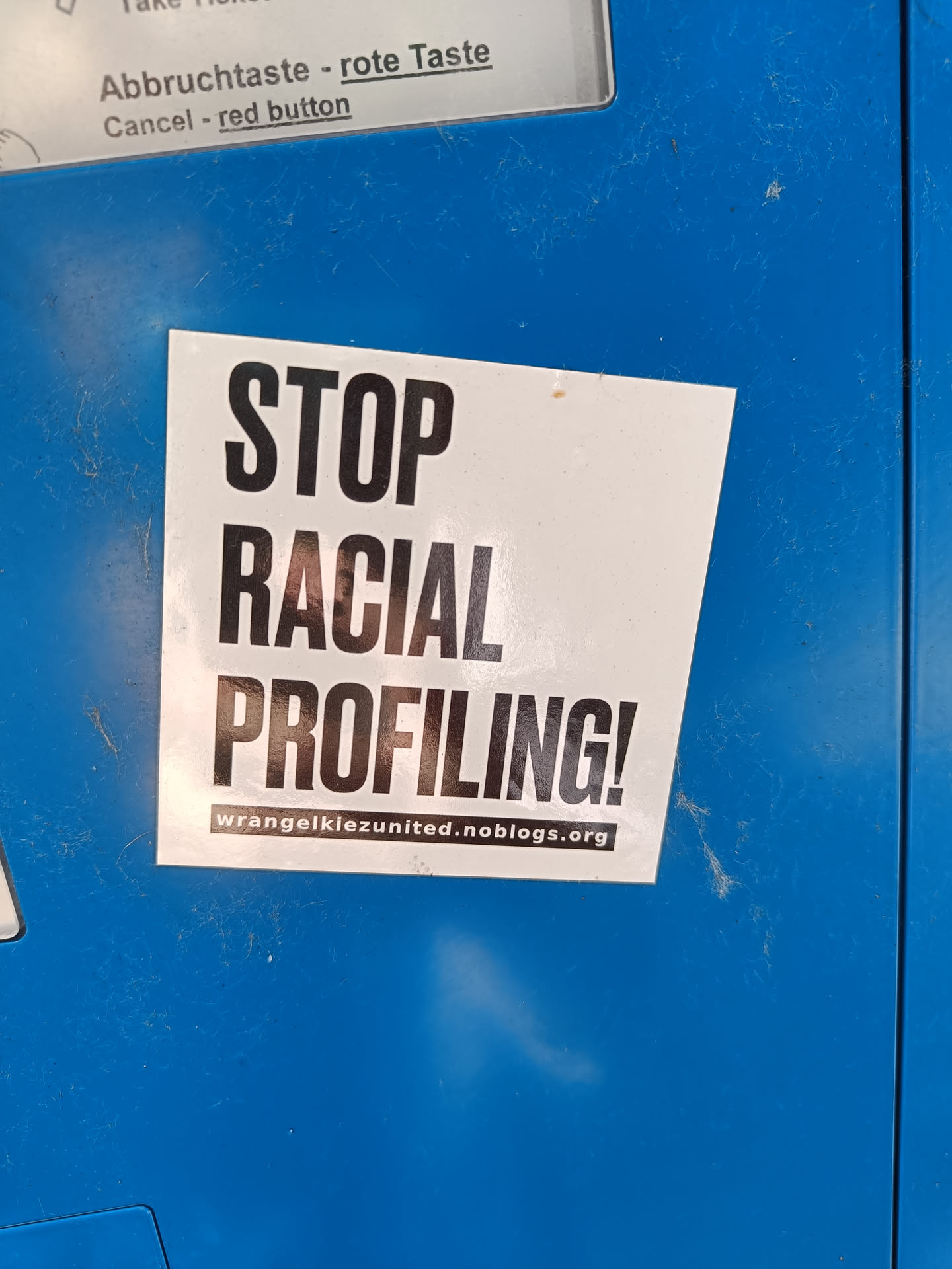 A sticker expressing protest against racial profiling.  It features bold text and a website address.