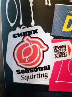 White sticker with a red peach design and the text "CHEEX Seasonal Squirt".  It also includes a QR code.